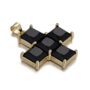 Detail of a gold cross pendant featuring five square black stones in a claw setting