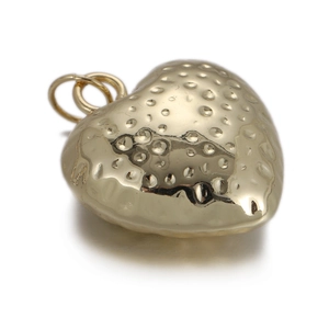 Detailed view of heart-shaped gold charm with unique hammered texture for DIY jewelry