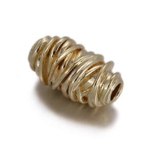 Detail of a cylindrical copper bead with intricate spiral wire texture for DIY jewelry