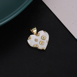 Golden heart pendant with white mother of pearl and zircon accents on textured background