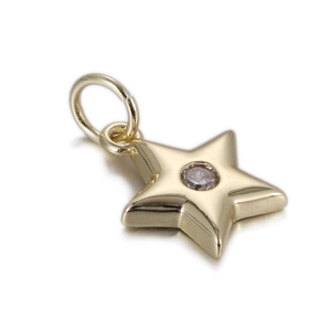 Close-up of a gold star charm pendant with a central sparkling zircon for DIY jewelry