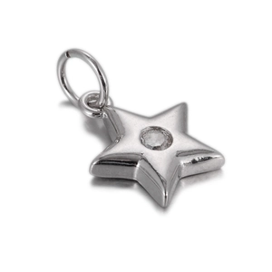 Close-up of a silver star-shaped pendant with a clear cubic zirconia stone inlay