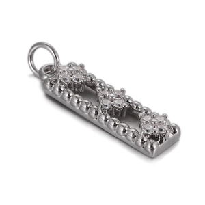 Macro view of rectangular silver pendant with floral zircon clusters and beaded edges