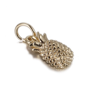 Macro shot of a golden pineapple charm with diamond texture and top loop for DIY jewelry