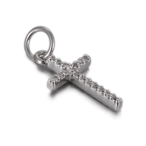 Close-up of a silver cross pendant with sparkling cubic zirconia on a white background