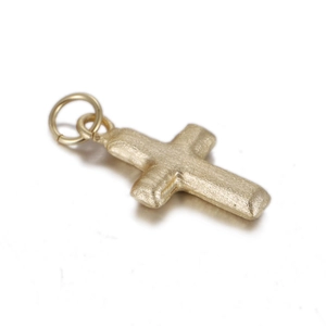 Detailed view of a brushed gold cross pendant with a smooth circular bail attachment