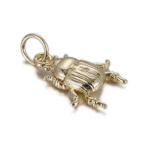 Detailed view of a gold beetle pendant with intricate striped engraving for DIY jewelry