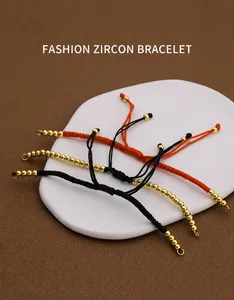 Drei verstellbare, handgeflochtene Armbänder mit Zirkon und Goldperlen in der Nahaufnahme