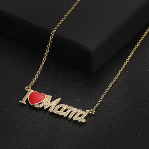 Vista macro della collana d'oro con ciondolo I love Mama e cuore rosso scintillante