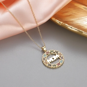 Dettaglio della collana con ciondolo MOM dorato con gemme colorate e motivi a cuore