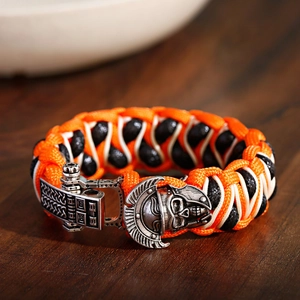 Detail van een handgeweven oranje paracord armband met een vintage Spartan helm bedel
