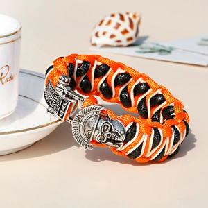 Detail van paracord armband met zilveren Spartan schedel metalen gesp en geweven koord