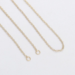Dettaglio di una catena per collana dorata con anellini e finitura in metallo lucido