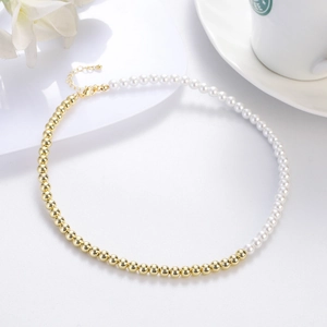 Detail of vintage pearl necklace featuring gold beads and butterfly pendant on white background