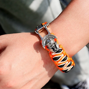 Detailopname van een gevlochten paracord armband met een zilveren Spartaanse helm sluiting