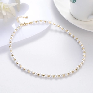 Elegante Perlenkette mit Goldperlen und Karabinerverschluss auf weißem Grund