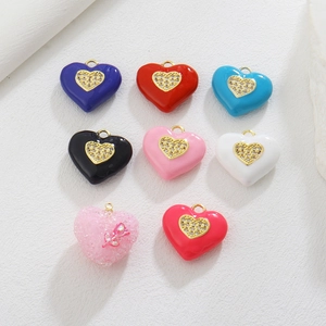 Detailed view of colorful heart-shaped enamel pendants with inlaid cubic zirconia
