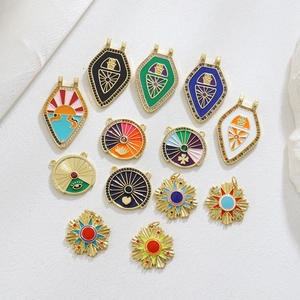 Detailed macro view of enamel tarot pendants with zircons and 18k gold plating