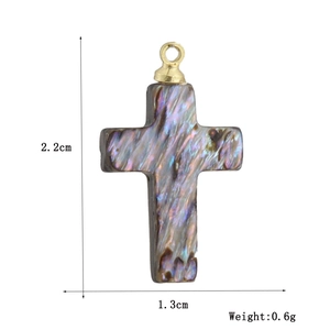 Détail d'un pendentif croix en nacre irisante de 2,2 cm avec anneau en métal doré