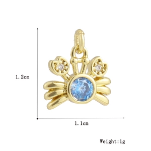 Macro detail of crab pendant in 18k gold plated copper with blue stone and zirconia
