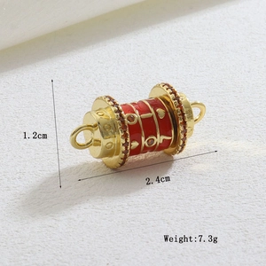 Macro detail of luxury prayer wheel pendant with red enamel heart and orange gems