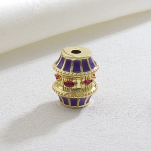 Detailed view of luxury gold bead with purple enamel and red zircon insets for DIY jewelry