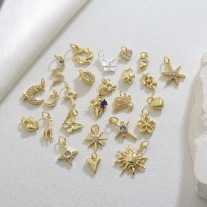 Dettaglio macro di vari ciondoli per gioielli fai-da-te placcati in oro con pietre di zircone