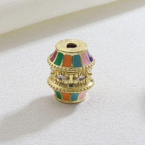 Detailed shot of gold-plated barrel bead with colorful enamel and zircon stones
