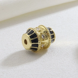 Macro shot of gold barrel bead with black enamel and marquise cubic zirconia stones