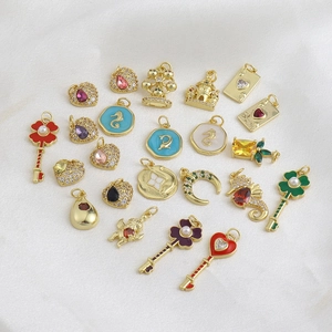 Vue à plat de breloques DIY plaquées or 18k en forme de cœur et de clé avec des zircons