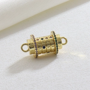 Macro shot of rotating golden barrel pendant with colorful zircon and LOVE engraving