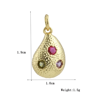 Vue macro d'un pendentif goutte martelé plaqué or 18k de 1,9cm avec pierres précieuses