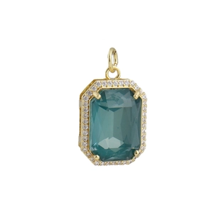 Detail van een 18k vergulde hanger met een grote smaragdgroene edelsteen en micro-pave rand