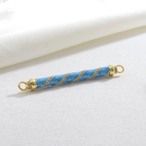 Detailed view of light blue enamel barrel bead with gold plating and sparkling zircon stones