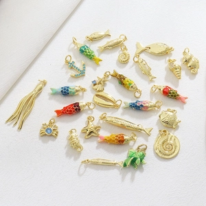 Macro view of nautical sea life pendants with 18k gold plating and colorful enamel detailing