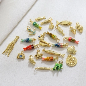 Macro shot of colorful enamel marine charms like fish and seahorses in 18k gold plating