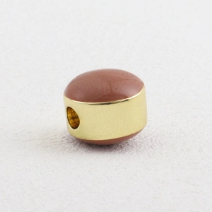 Macro shot of 18k gold plated drum bead with reddish brown stone for DIY jewelry