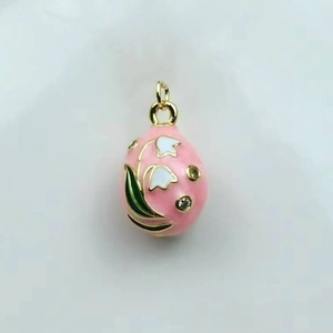 Detail of pink enamel Russian egg pendant with white lily of the valley and 18k gold plating