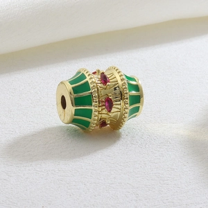Luxurious gold barrel charm with green enamel stripes and red marquise-cut stones