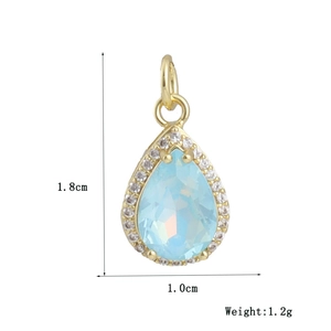 Macro-opname van een vergulde peervormige hanger met blauw kristal en zirkonia