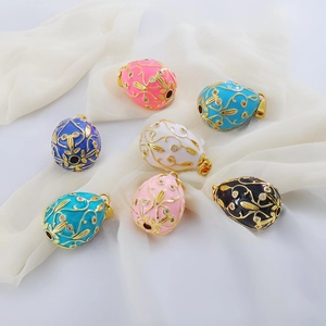 Detail of 18k gold-plated enamel egg pendants with intricate gold filigree and tiny rhinestones
