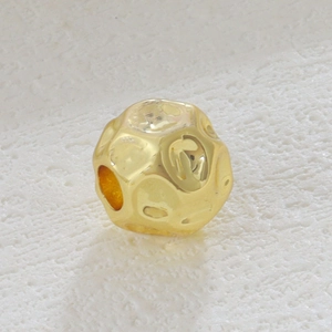Vista macro de cuenta martillada chapada en oro 18k para creación de joyas DIY