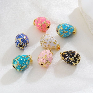 Detail of colorful Faberge-style egg pendants with gold filigree and crystals on silk