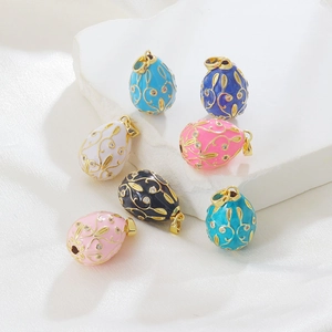 Detail of colorful enamel egg pendants with gold floral filigree and zircons for DIY jewelry