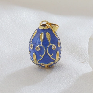 Detailed macro of a Faberge-style blue enamel egg pendant with gold scrollwork and crystals