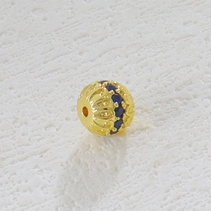 Vista macro de cuenta hueca bañada en oro 18k con gema azul para creación de joyas DIY