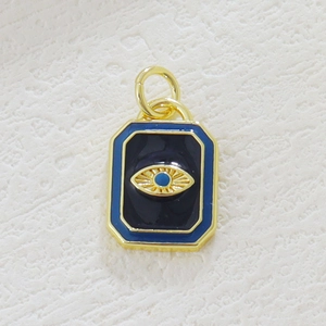 Macro detail of rectangle gold-plated evil eye charm with blue enamel inlay work