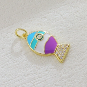 Macro detail of a colorful fish-shaped enamel pendant with sparkling small rhinestones