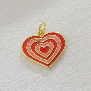 Detail of 18k gold heart pendant with layered red and pink glitter enamel finish