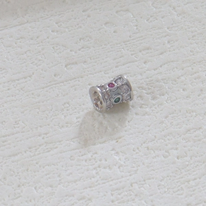 Detalle de una cuenta cilíndrica con circonitas de colores para la creación de joyas